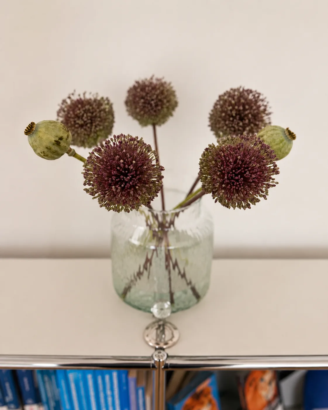 Allium-Blumen in einer Glasvase auf dem Sideboard der Praxis.